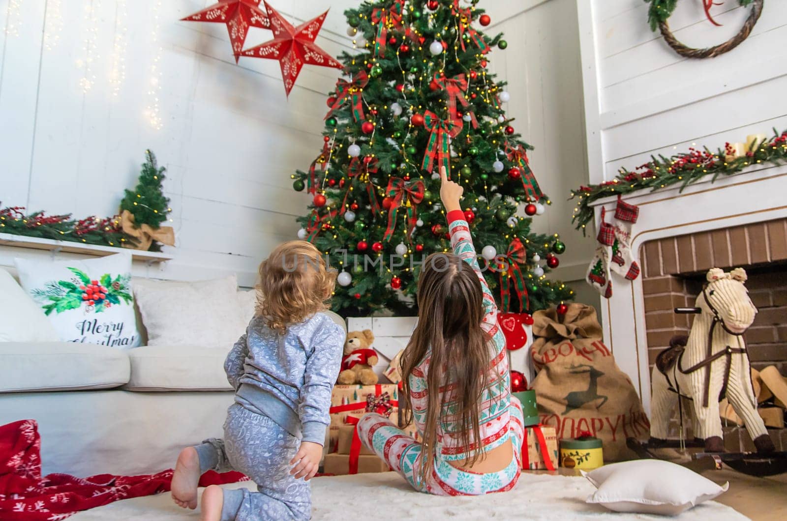 Children look at the Christmas tree. Selective focus. Kid.