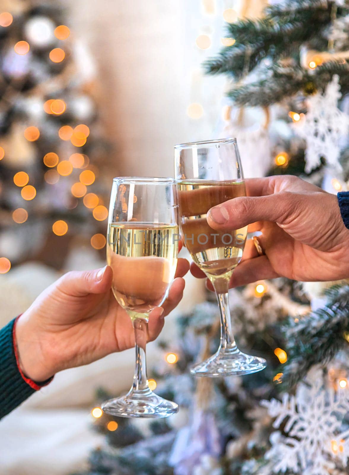 Man and woman with champagne in their hands near the Christmas tree. Selective focus. Couple.