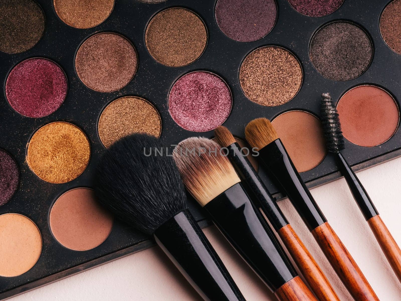 makeup brush set and professional eye shadow palette close up