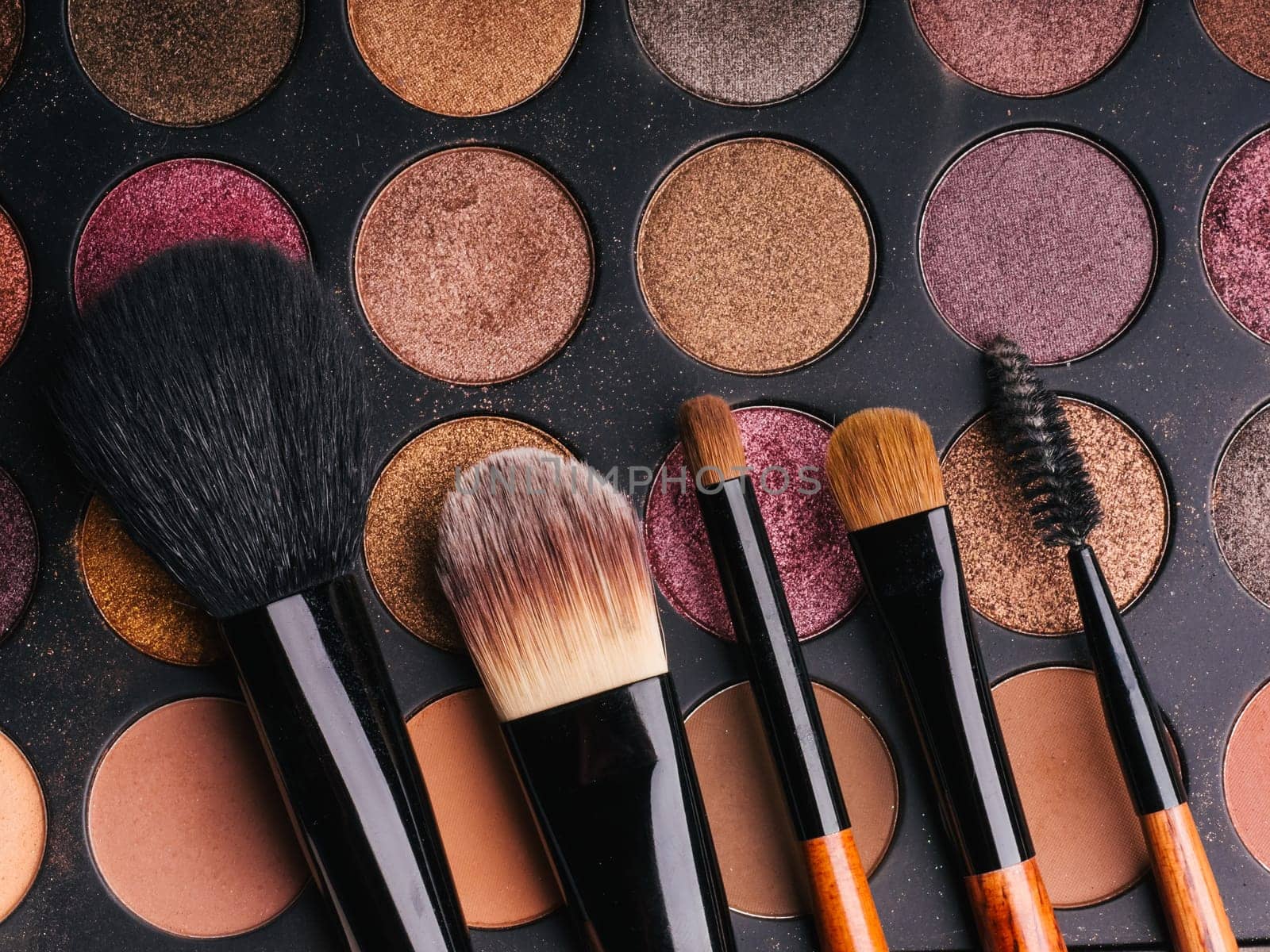 makeup brush set and professional eye shadow palette close up