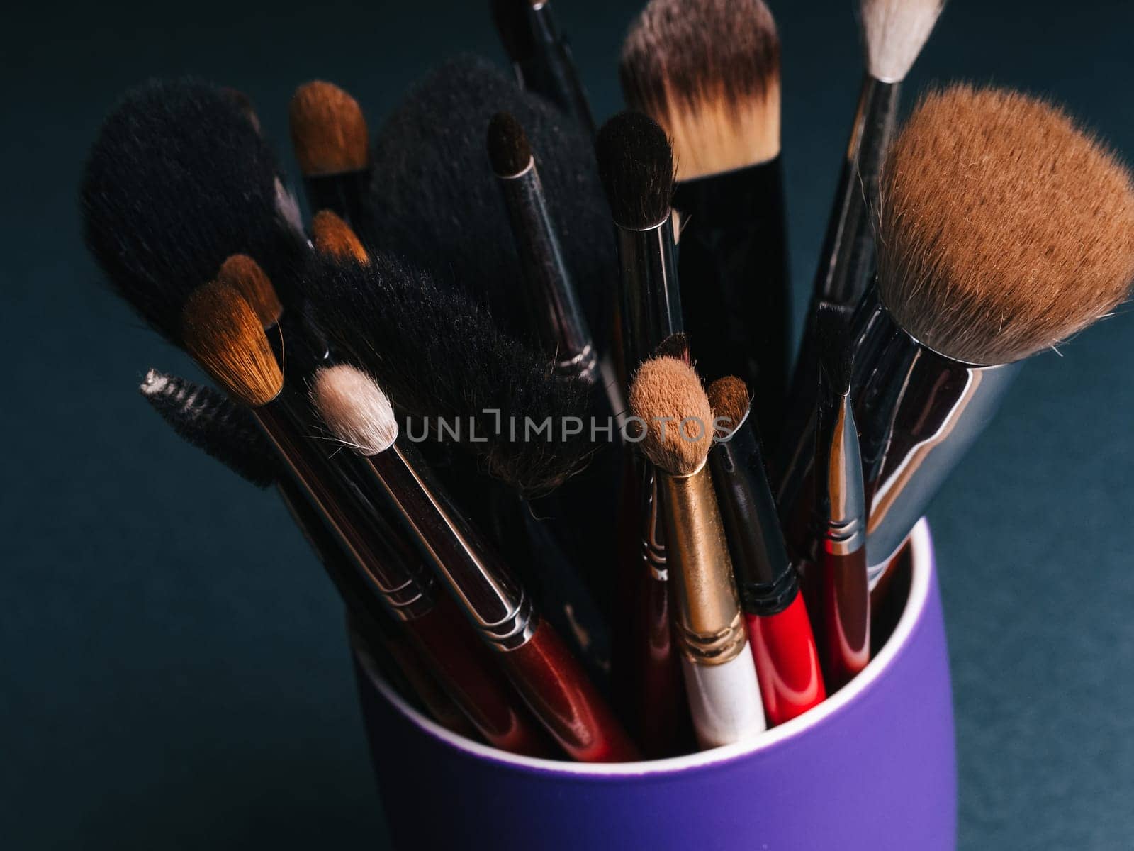 set of professional makeup brushes close up on dark background