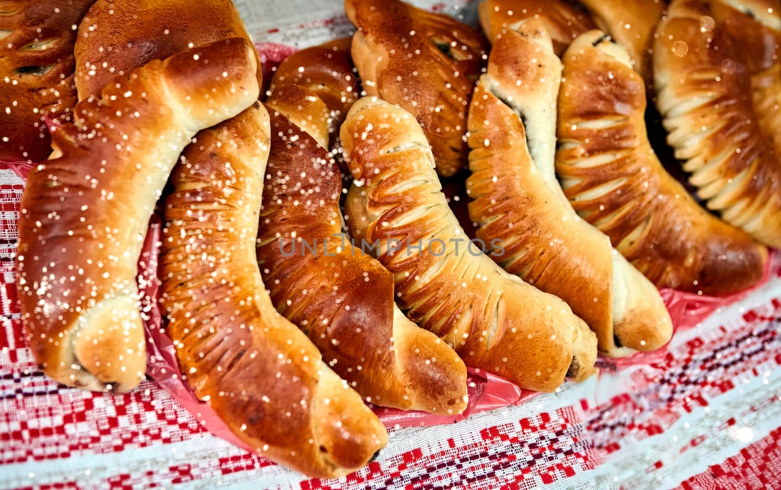 A close-up of freshly baked homemade puff pastry horns filled with rich chocolate cream on a red checkered tablecloth. Golden brown and flaky pastry, perfect for a sweet breakfast or snack.