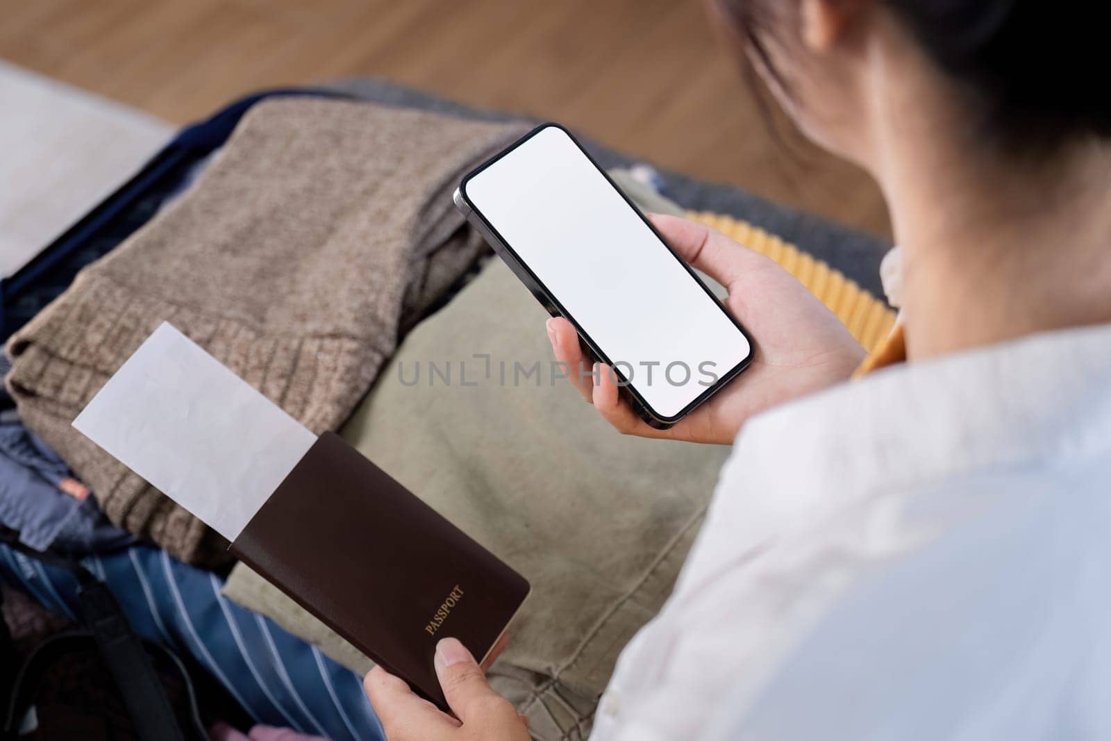 Travel concept. woman packed suitcase on floor in home, smartphone screen mockup.