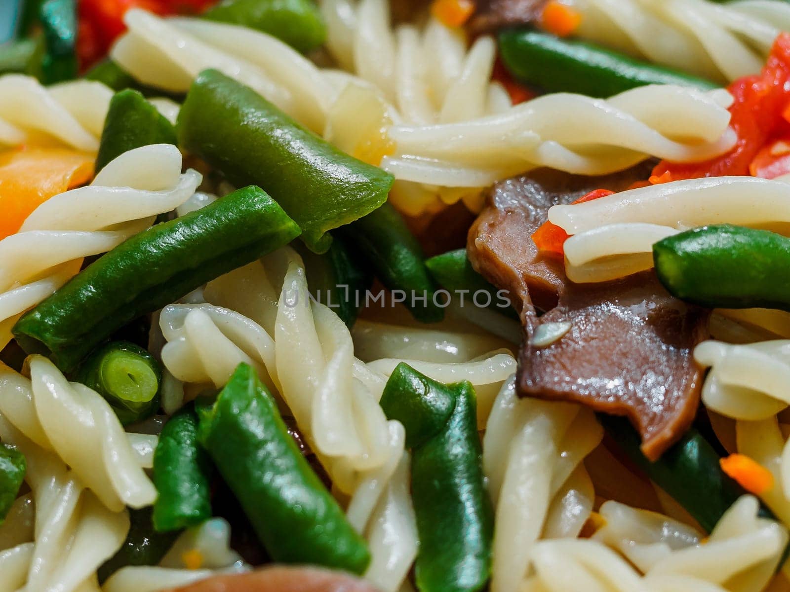 fusilli pasta with vegetables and mushrooms close-up