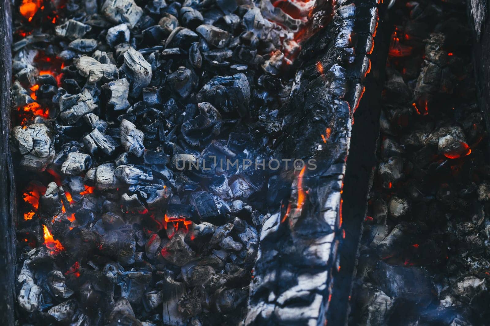 burning wood and hot red coals in the fire close-up