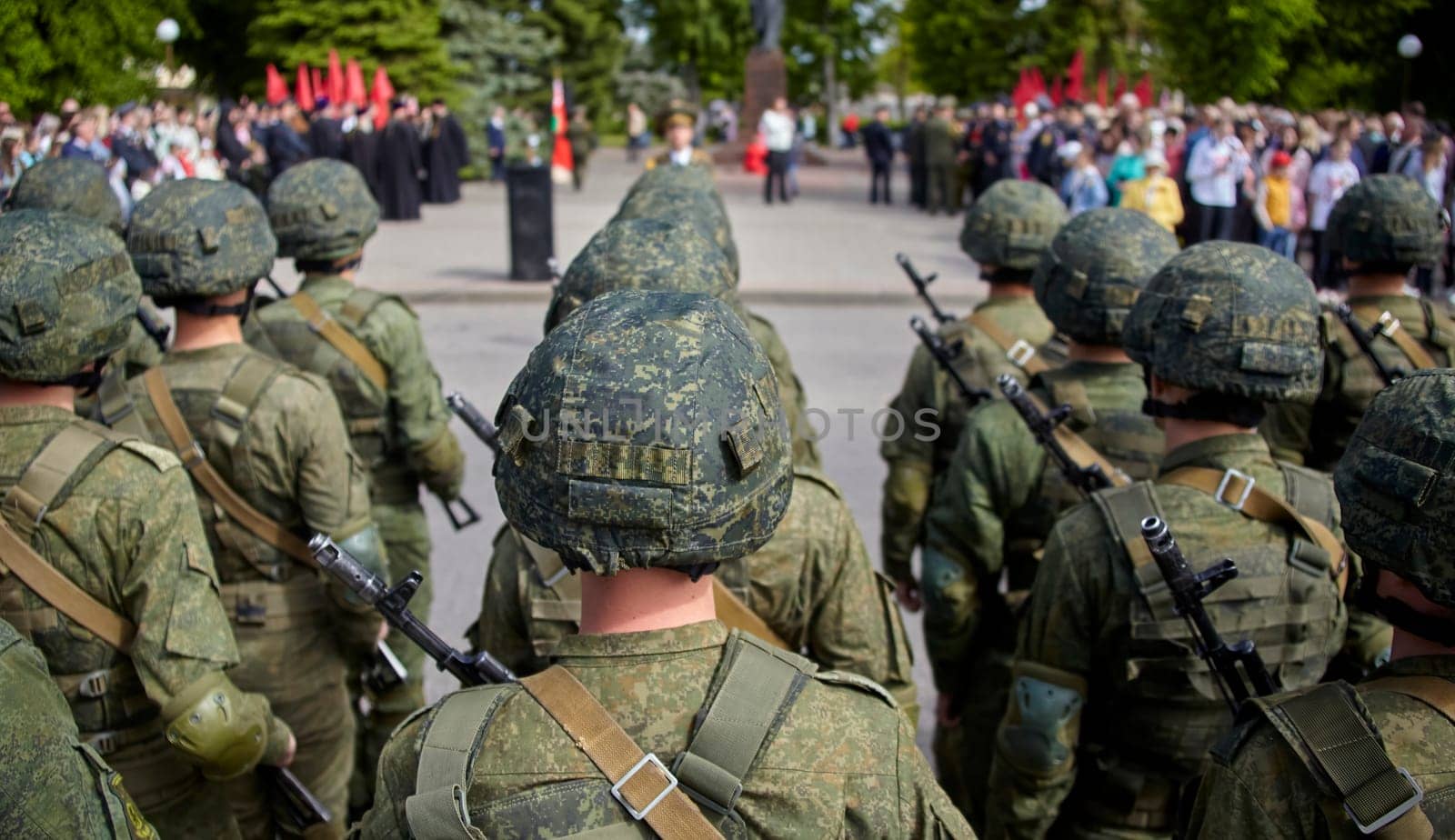 Soldiers in camo uniforms and helmets, armed with rifles, march in a parade displaying military might and discipline. This image captures the essence of military power and patriotism.