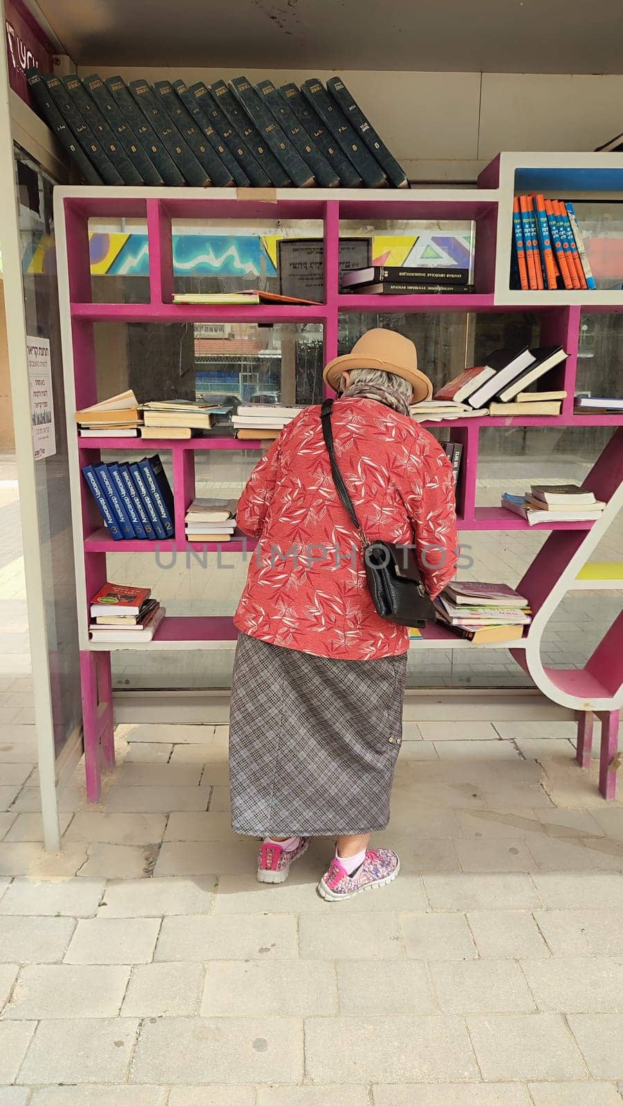 18 April 2024 Beersheva Israel, woman choosing books on a street bookshelf. High quality photo