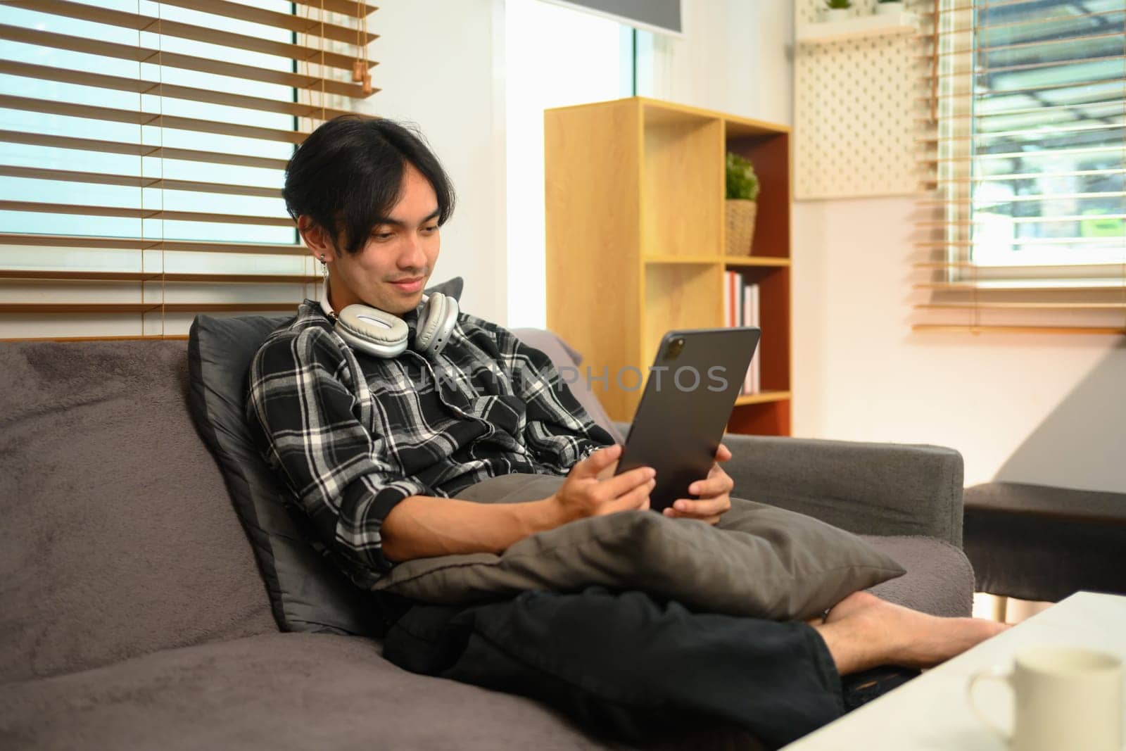 Shot of casual man scrolling news in social media on digital tablet.