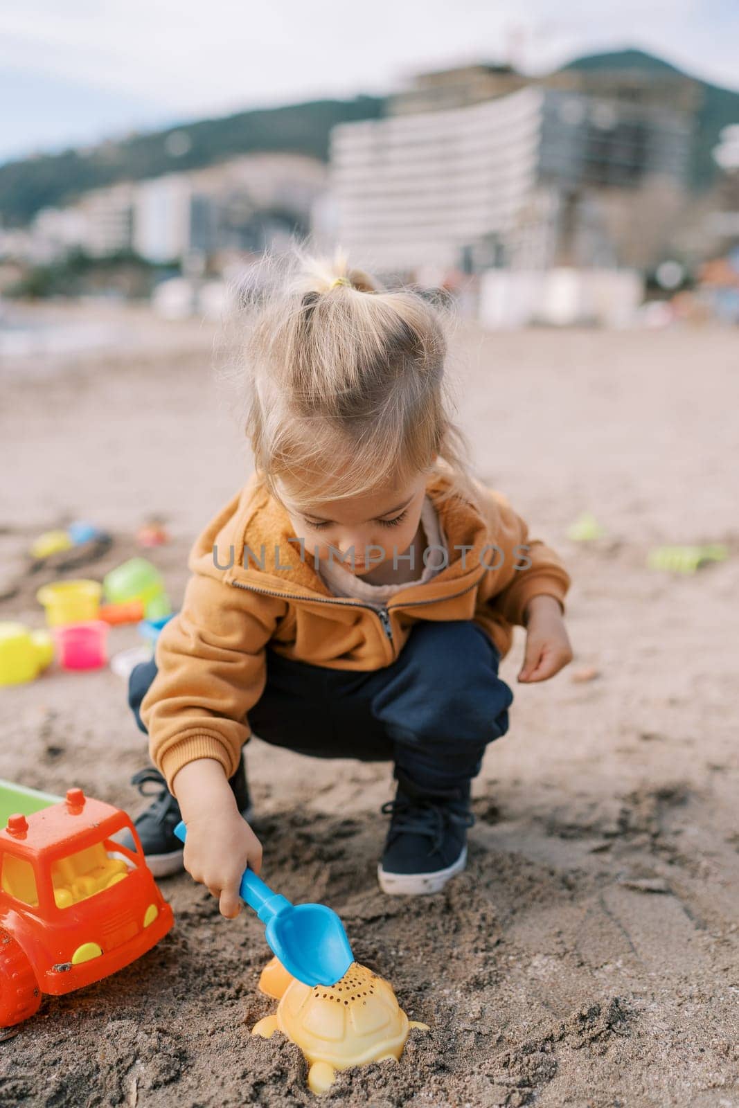 Little girl is squatting on the beach and enthusiastically digging the sand. High quality illustration