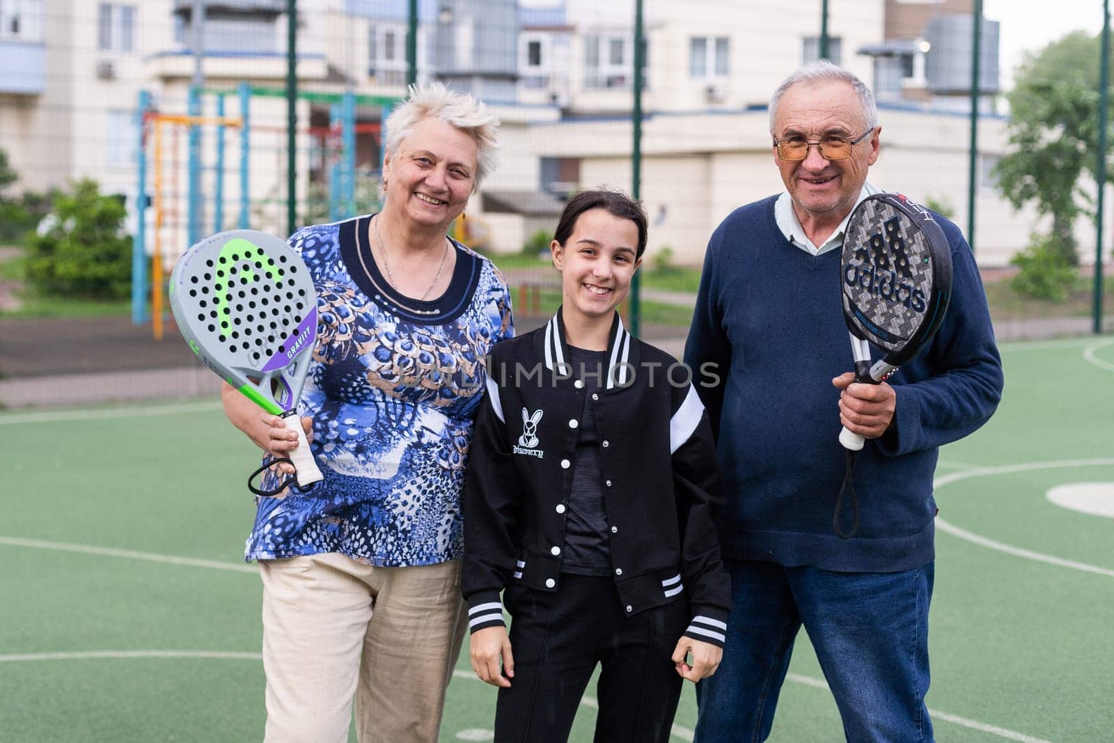 Ukraine, Kyiv, May 05, 2024, Happy cheerful positive smiling padel players of different generations posing on padel court. High quality photo