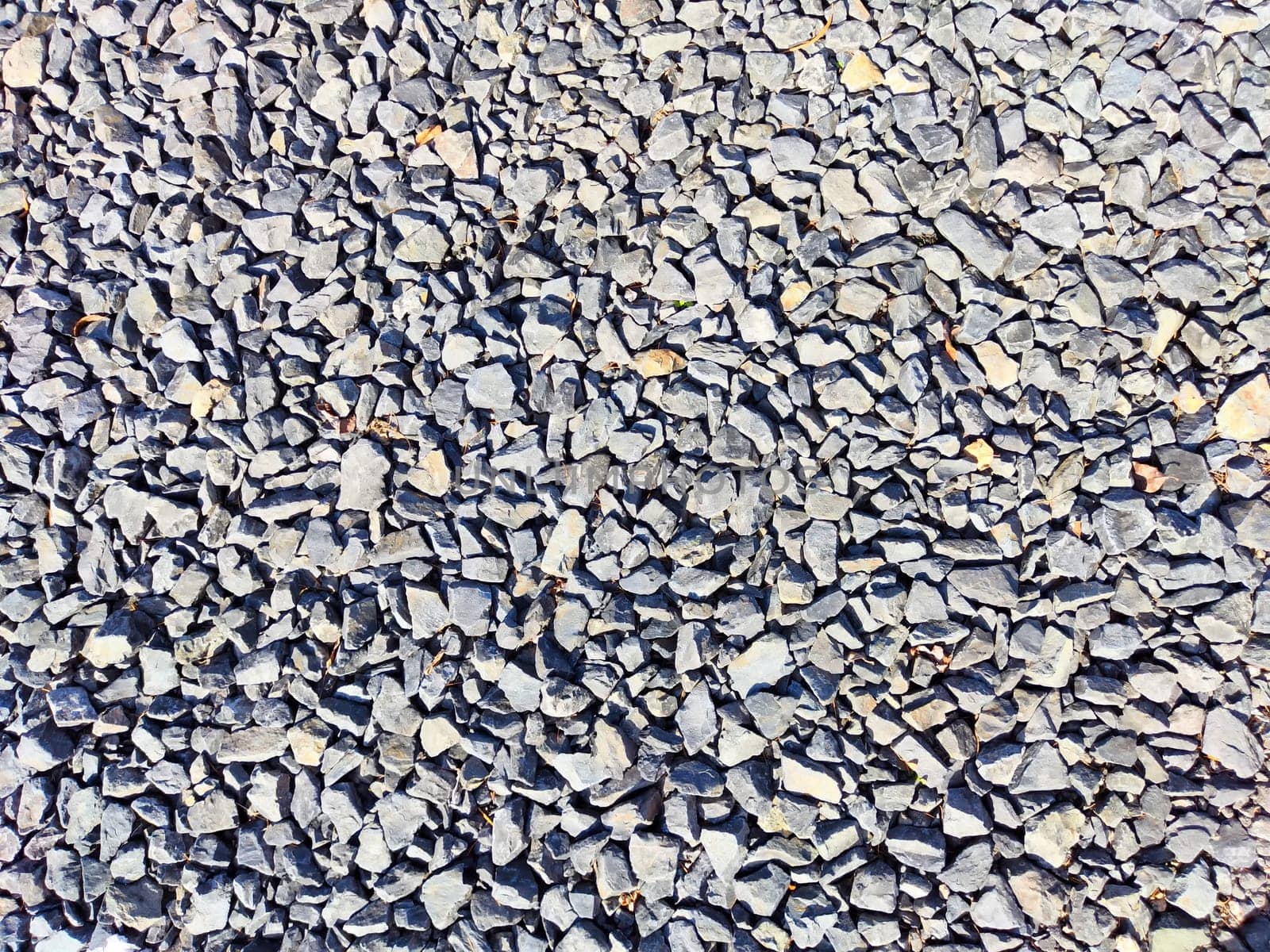 Stone asphalt texture of road in a day. Grey asphalt road and gravel. Background pebble and gravel