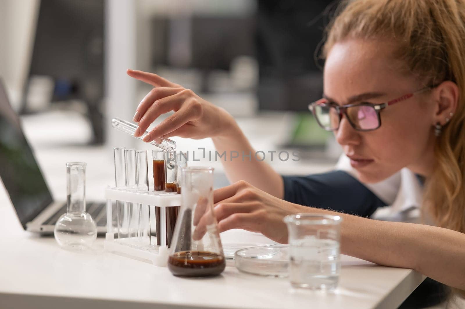 Caucasian woman in a medical gown doing laboratory experiments. by mrwed54