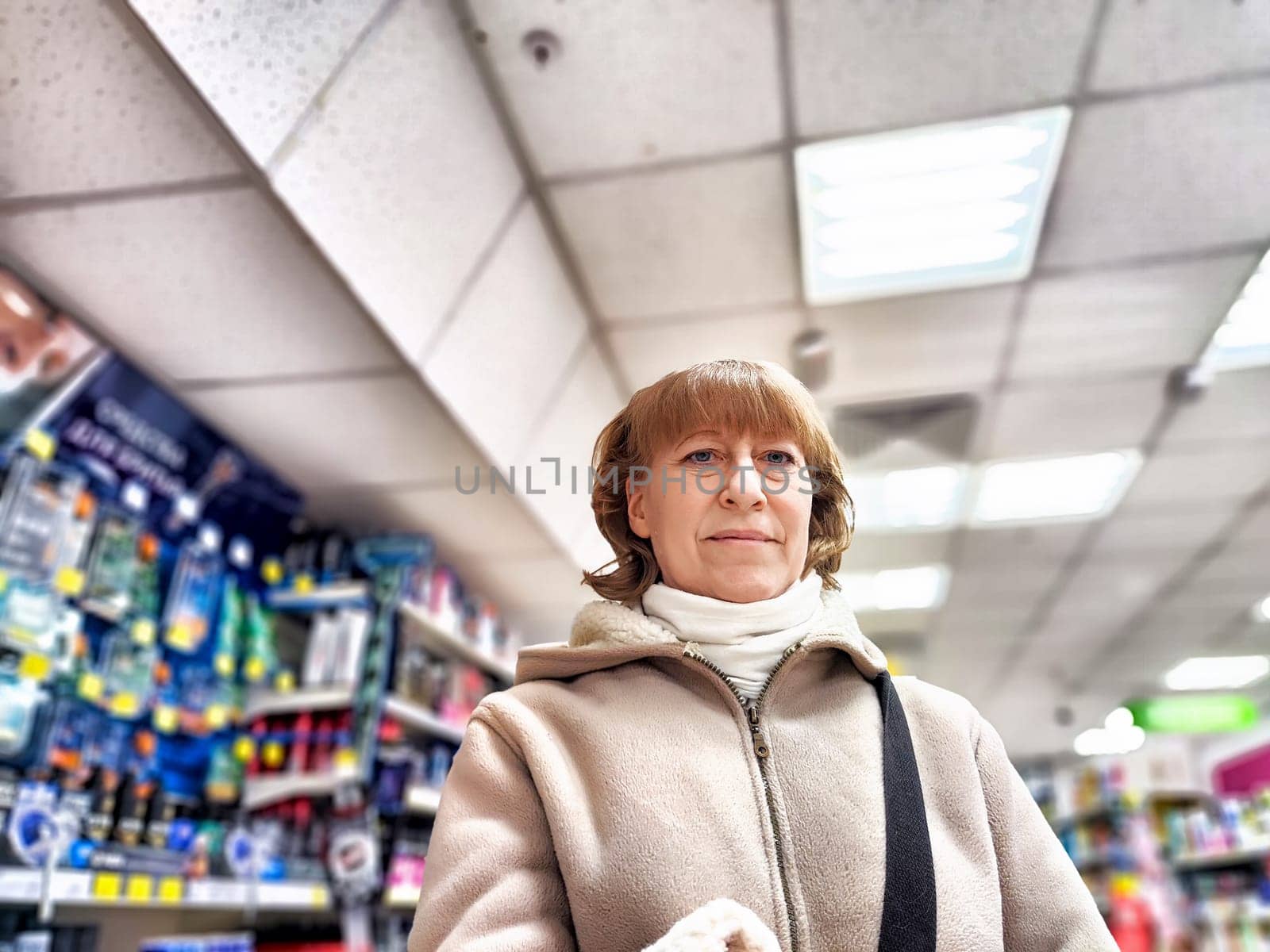 Middle-Aged Woman Shopping for Care Products at a Cosmetics Store. A woman browsing care products in a well-stocked cosmetics aisle by keleny