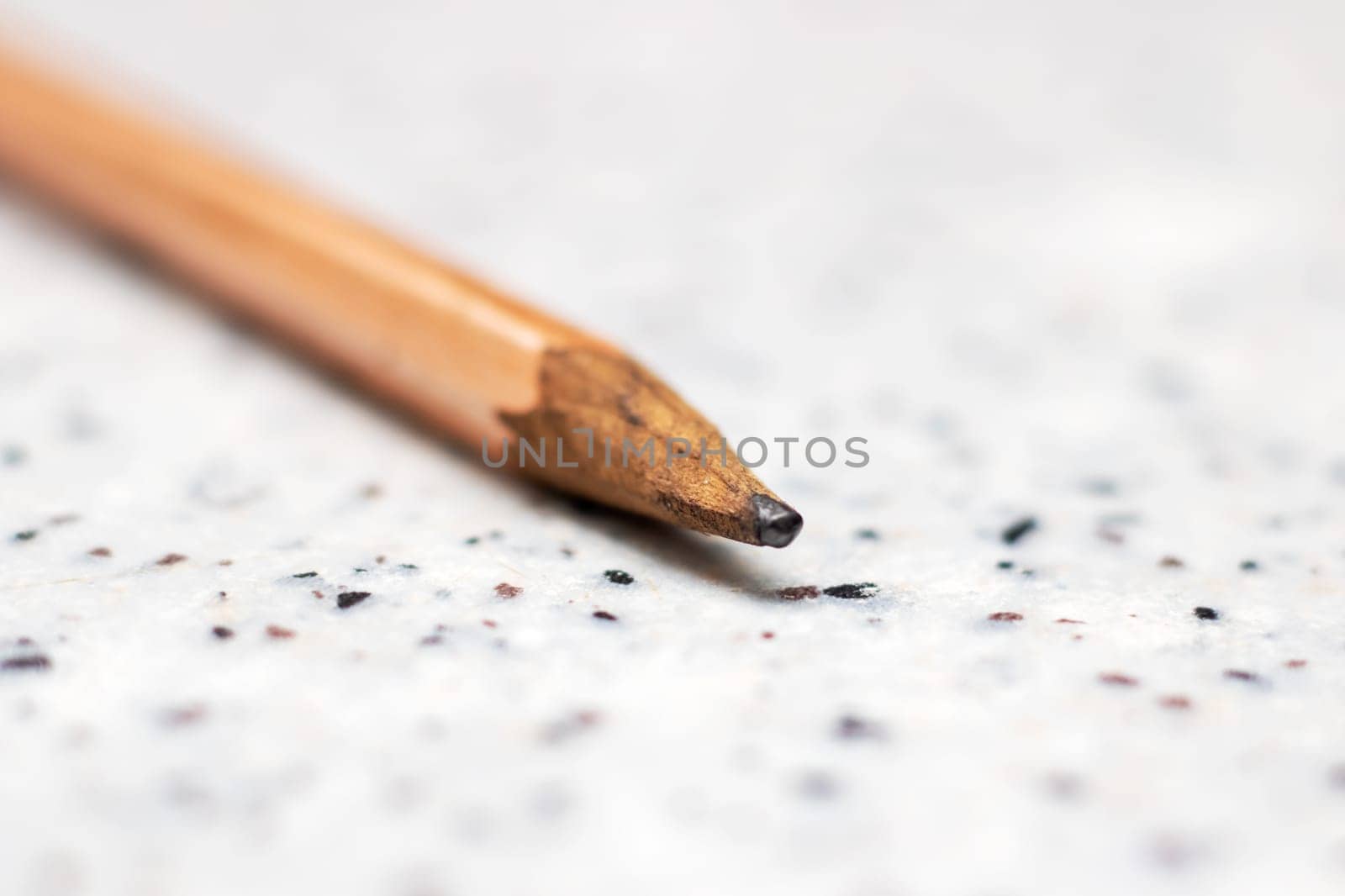 A closeup of a broken wooden pencil with graphite on a table, a writing implement accessory from office supplies made of natural materials