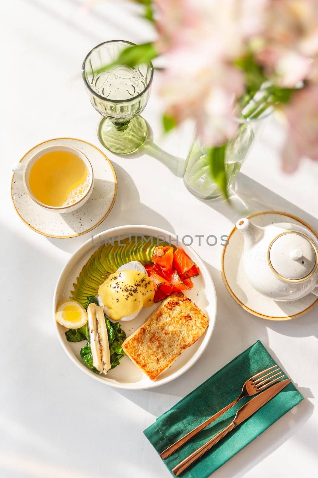 Light breakfast in a restaurant with green tea, toast, egg, avocado and salmon by bizzyb0y