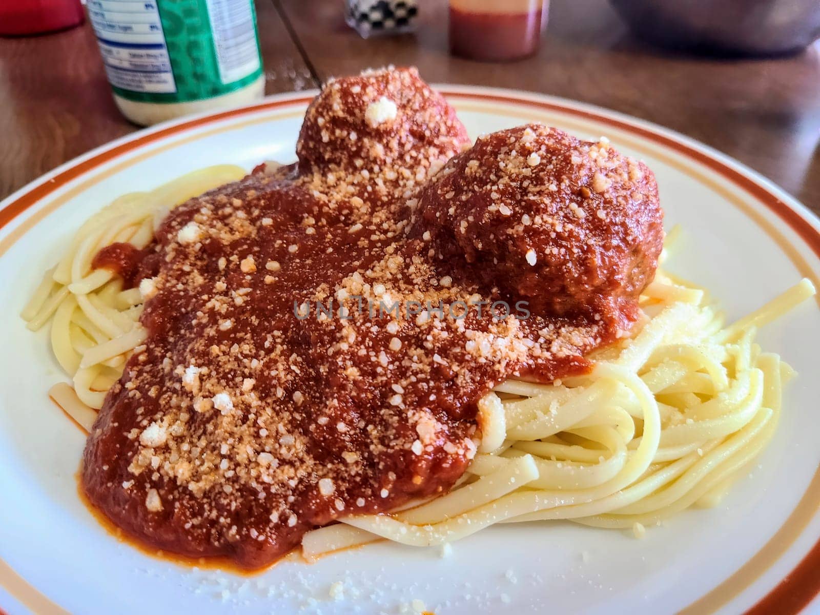 Hearty homemade spaghetti and meatballs on a rustic plate, garnished with parmesan, perfect for a family dinner.