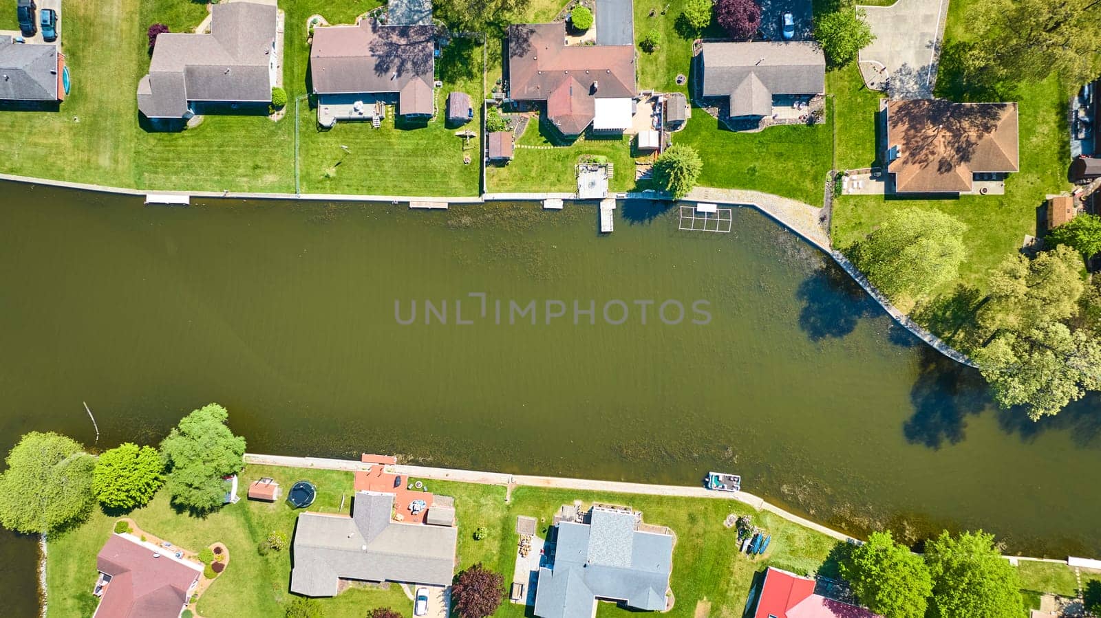 Aerial view of a peaceful riverfront neighborhood in Warsaw, Indiana, showcasing affluent suburban living.