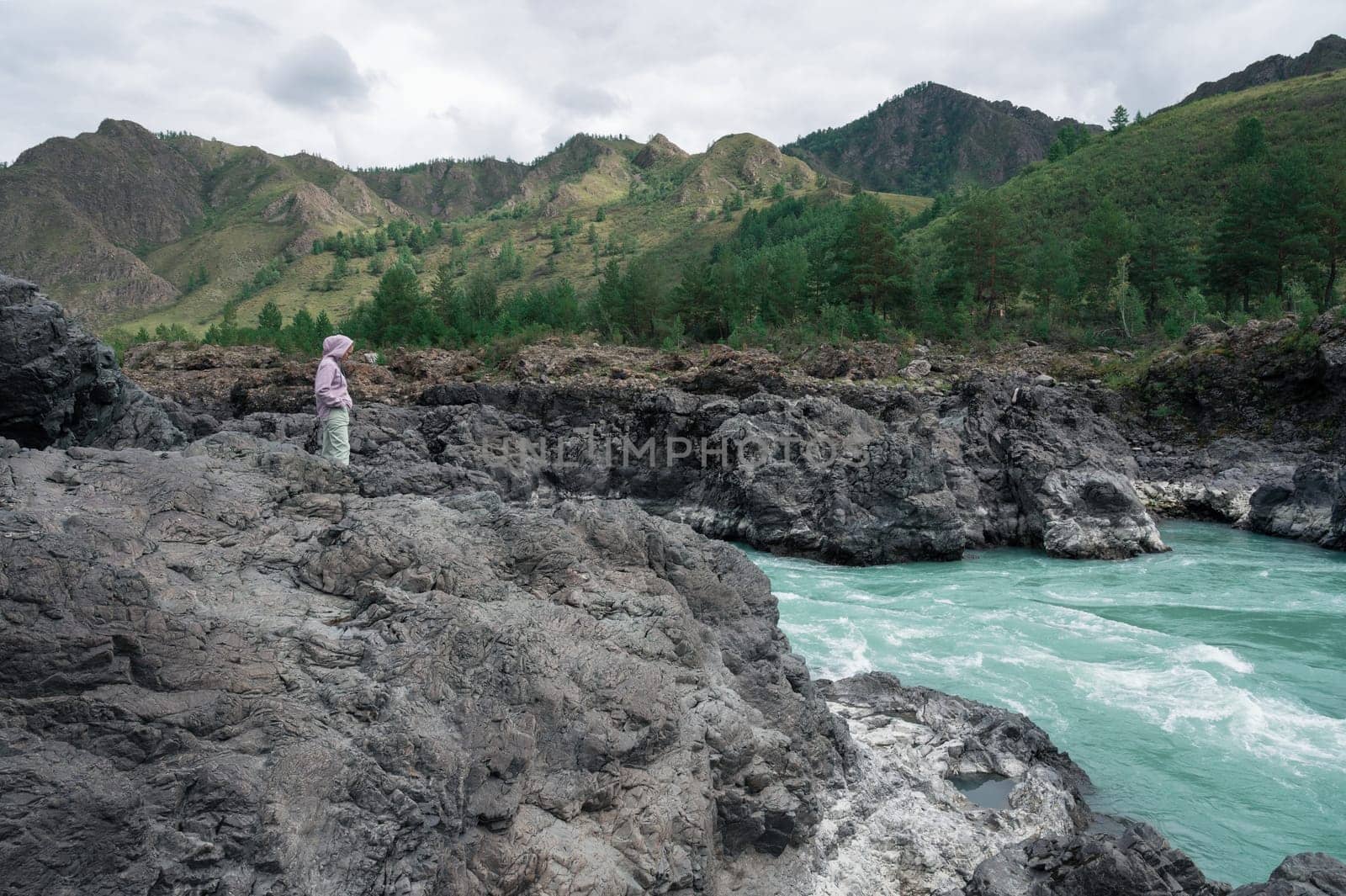 Woman at the river Katun at summer day. Trip on Altai Mountains in Altai Republic