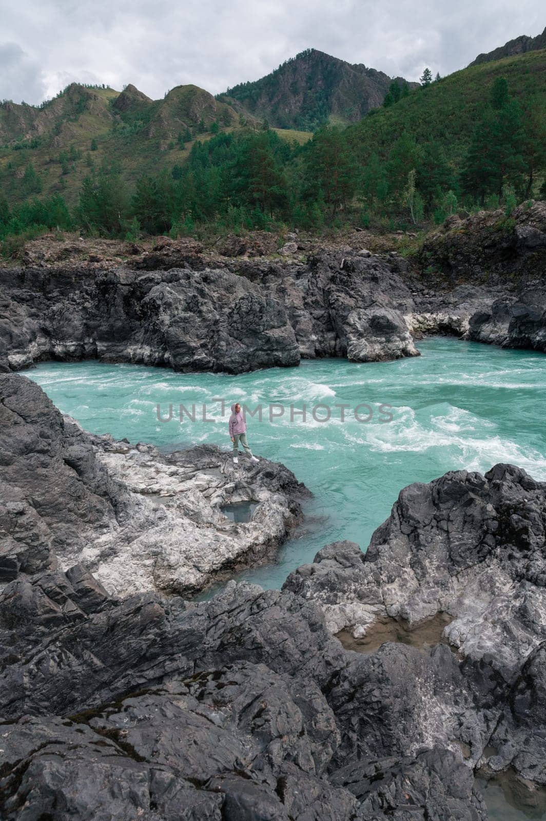 Woman at the river Katun at summer day. Trip on Altai Mountains in Altai Republic