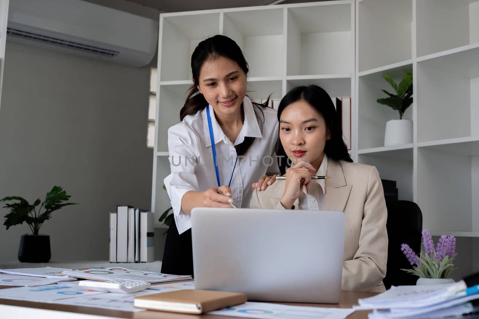 Team businesswomen discussing financial reports in office.