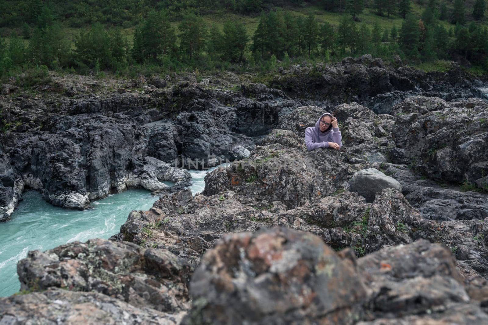 Woman at the river Katun at summer day. Trip on Altai Mountains in Altai Republic