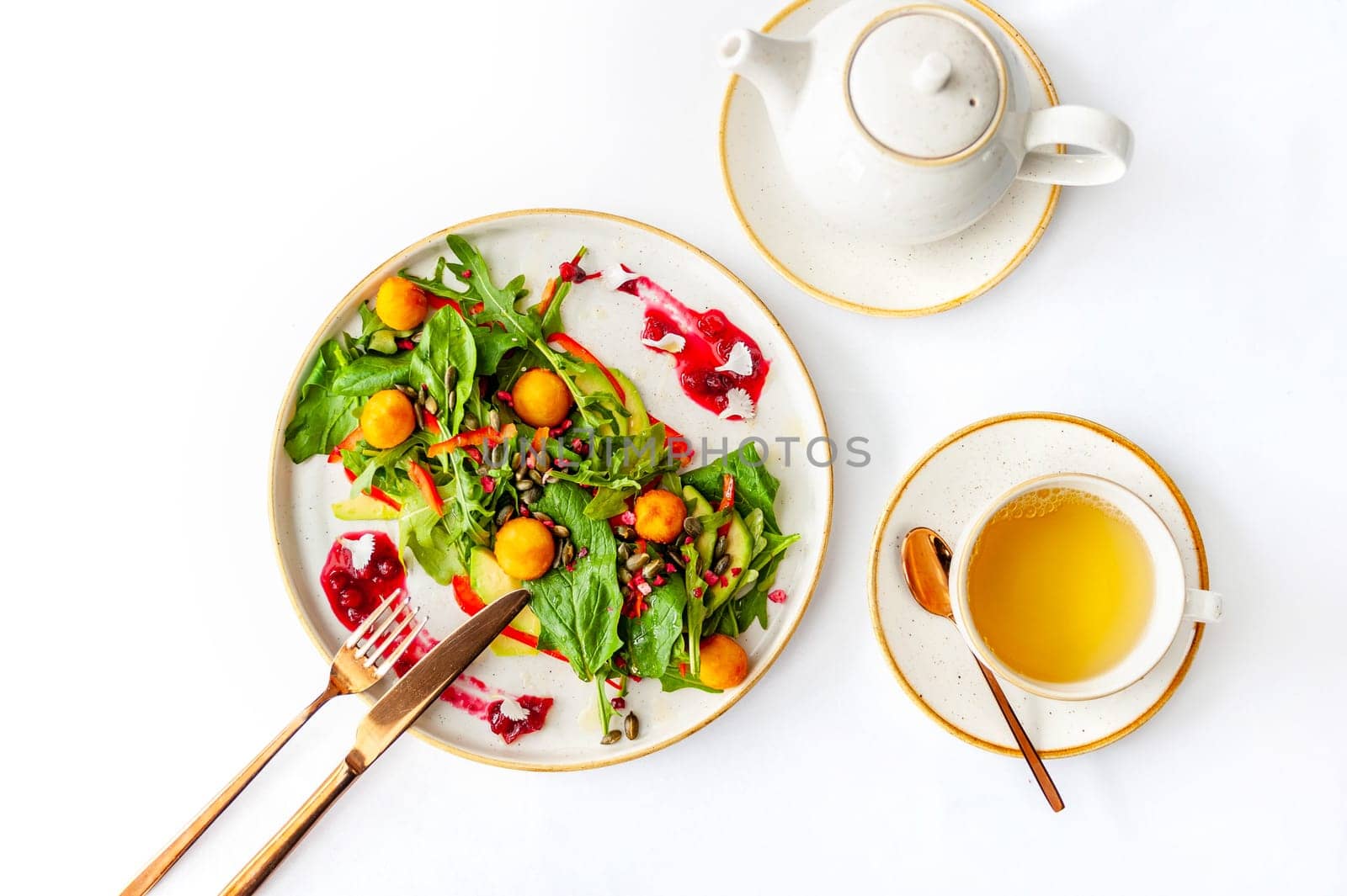 Light breakfast in a restaurant with green tea and salad. Shinat, arugula, avocado, pumpkin seeds. Isolated, top view.