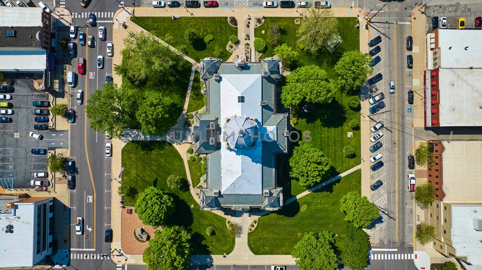 Aerial view of Kosciusko County Courthouse, Indiana, surrounded by lush greenery and busy city roads.