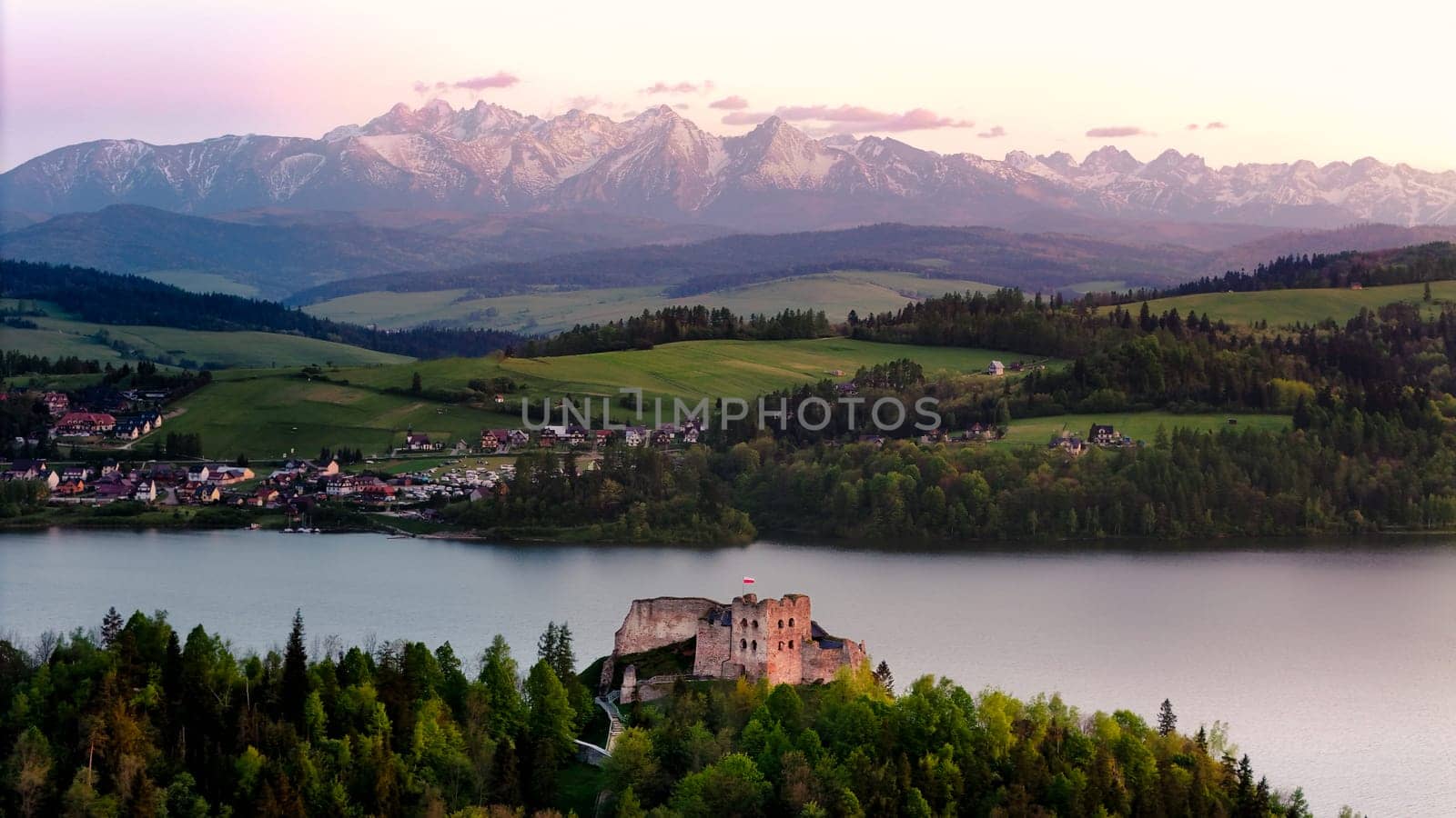 Medieval Castle in Niedzica by the lake and far view of the Tatra mountains. by Kustov