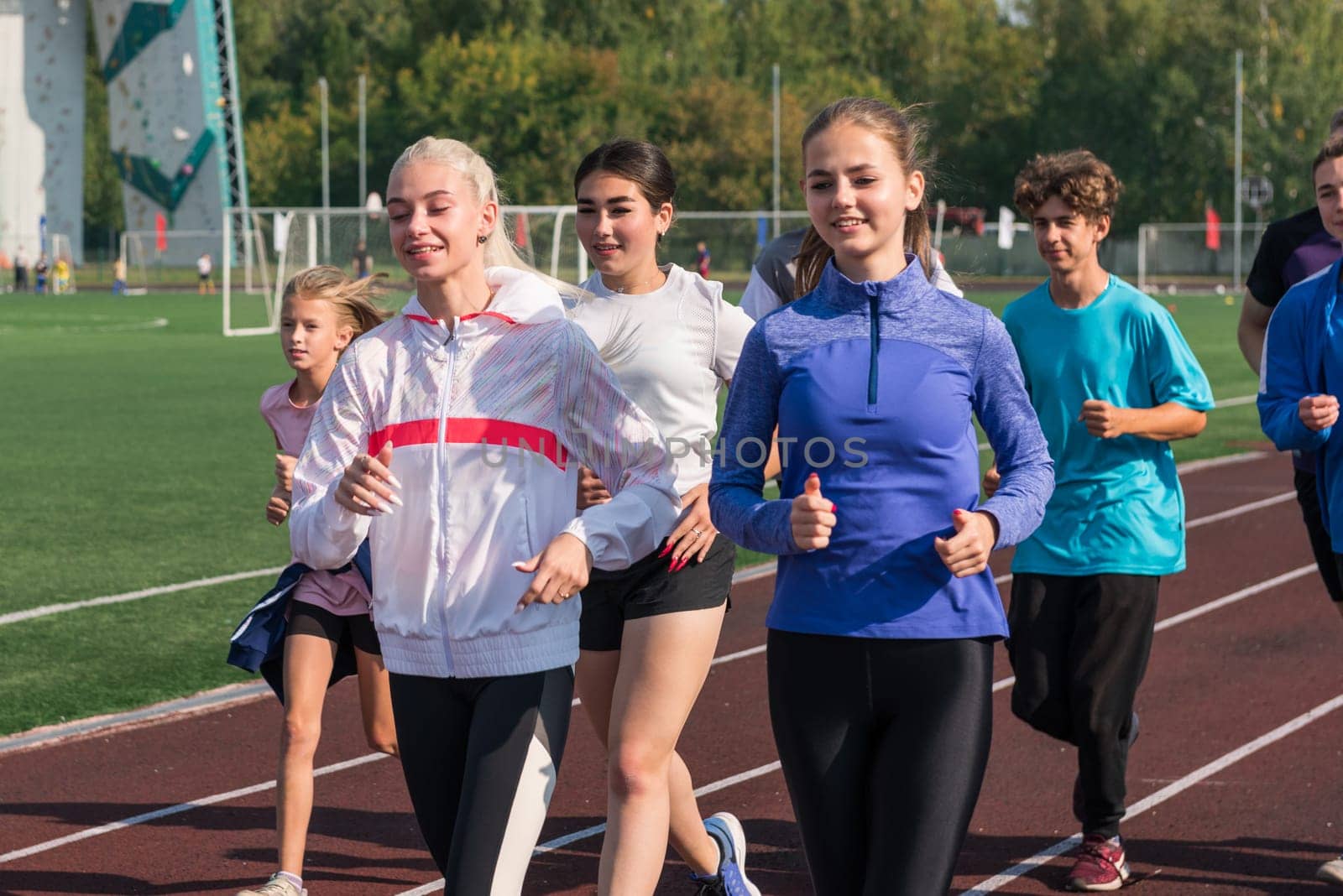 Group of young athletes training at the stadium by rusak