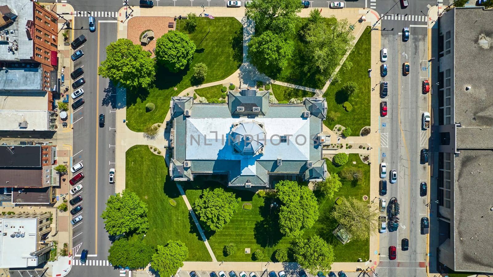 Aerial view of Kosciusko County Courthouse, Indiana, showcasing its neo-Gothic architecture and lush surroundings.