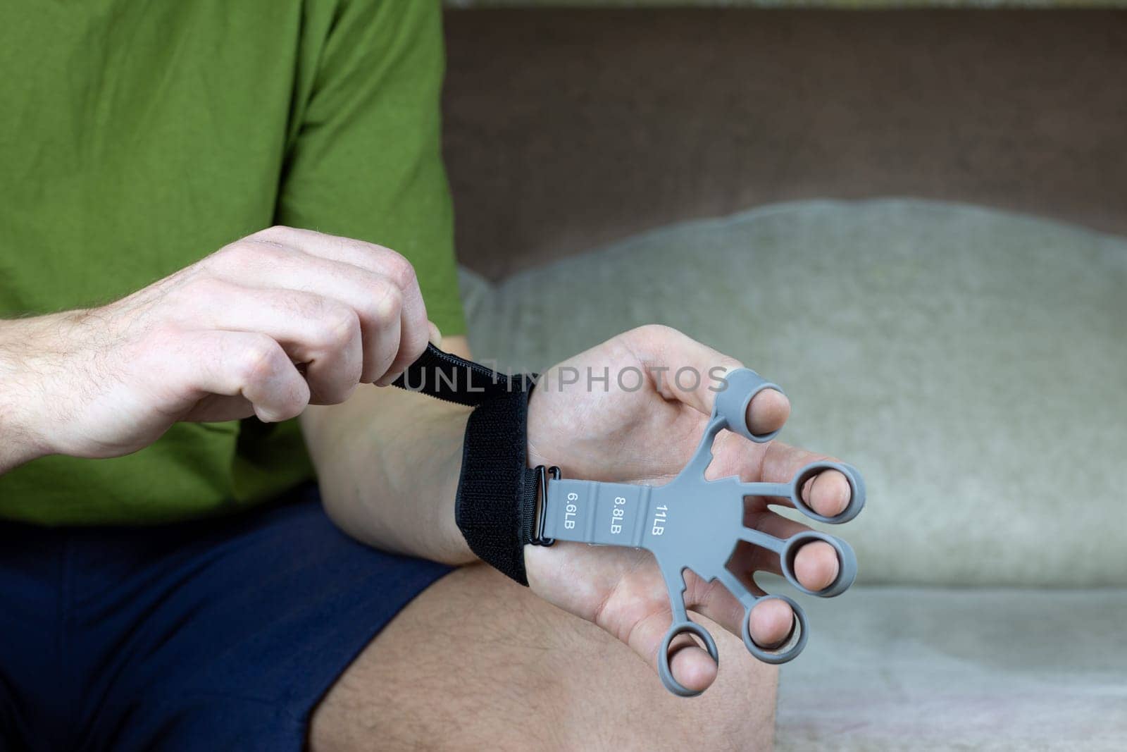 Hands are put on silicone finger trainer with special velcro fastening to extend the fingers and strengthen the hands