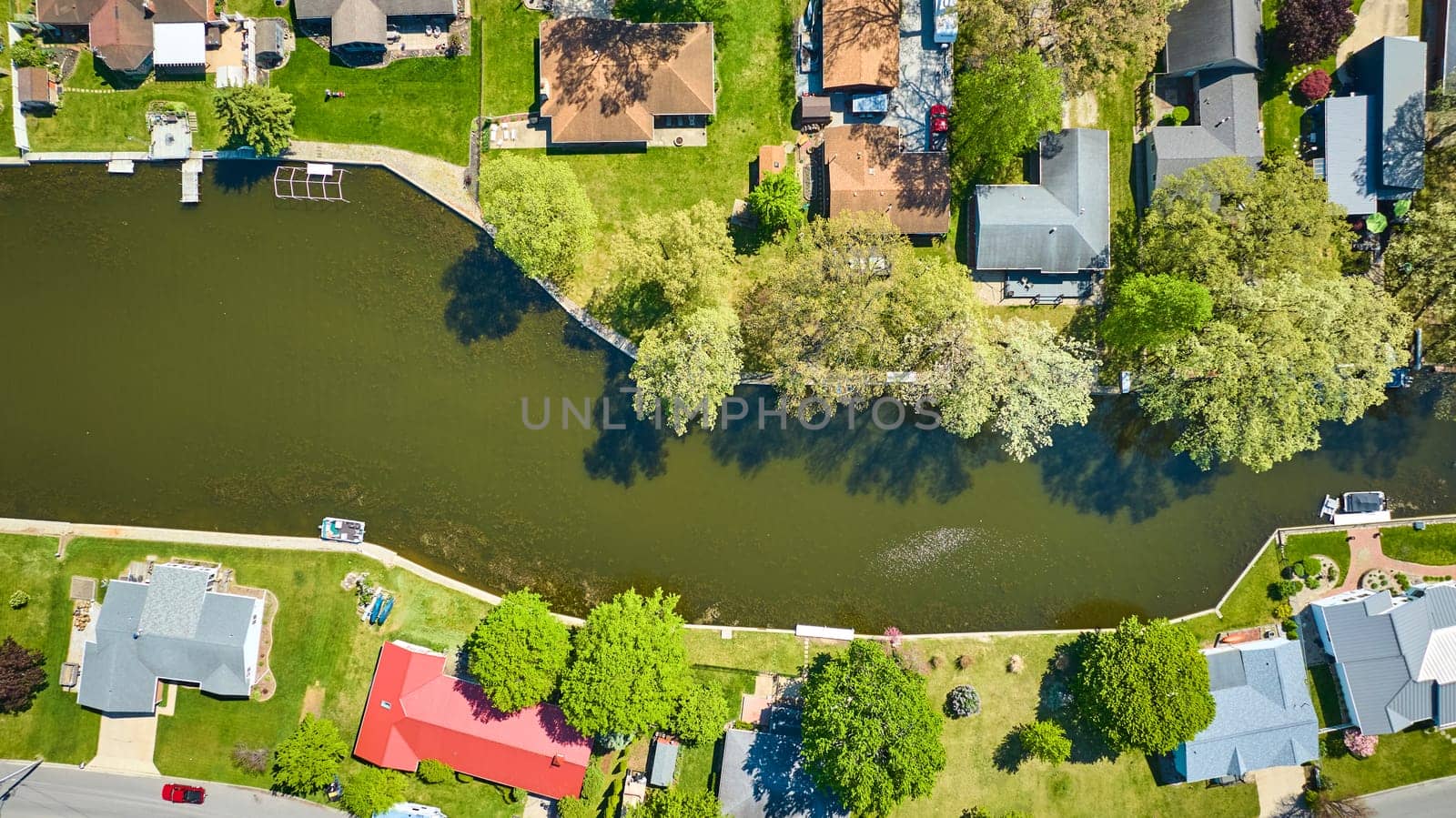 Aerial view of a peaceful suburban neighborhood in Warsaw, Indiana, showcasing homes with private docks on a serene lake.