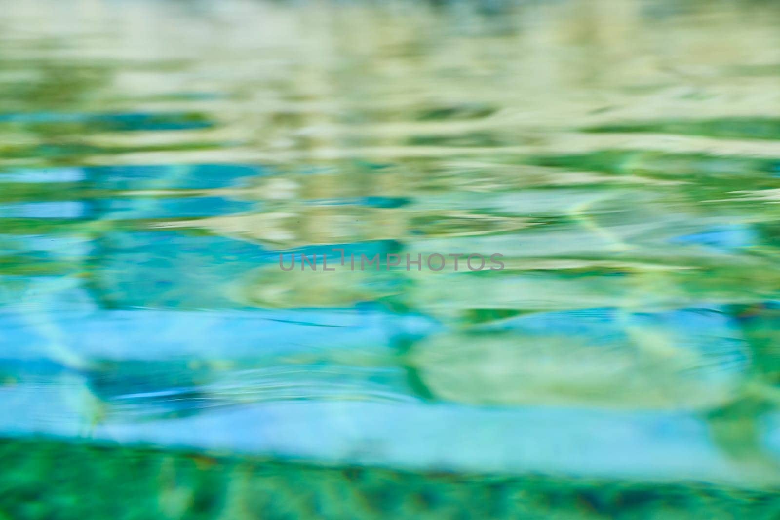 Abstract water texture in vibrant blues and greens, evoking serenity and nature's beauty. Ideal for wellness and art themes.