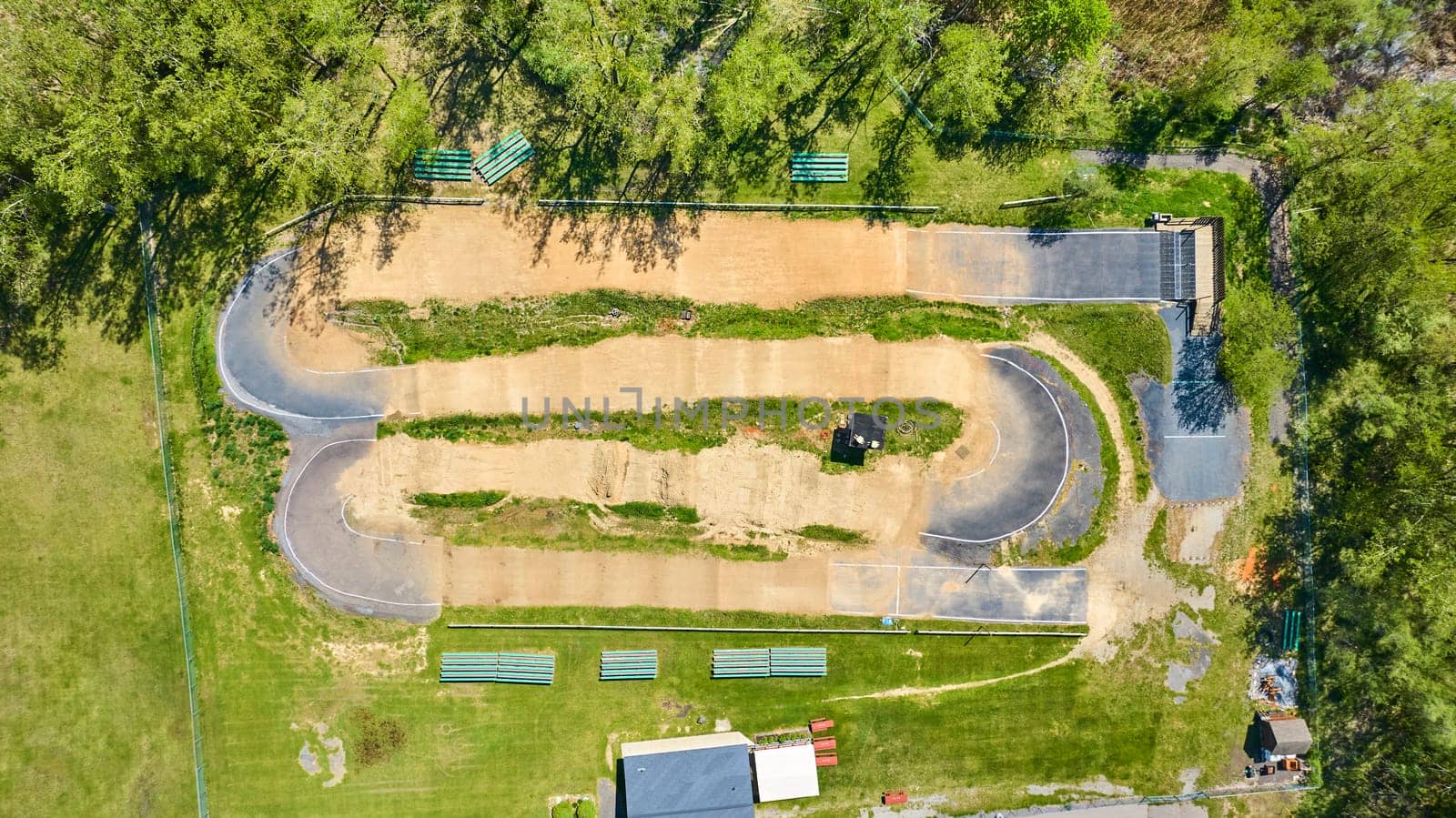 Aerial view of a vibrant park in Warsaw, Indiana, featuring a serpentine BMX track and lush green spaces.