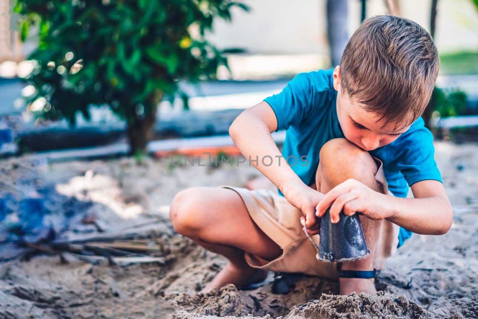 Child playing in sandbox. Happy childhood freedom creativity development, tactile Nature sensations.