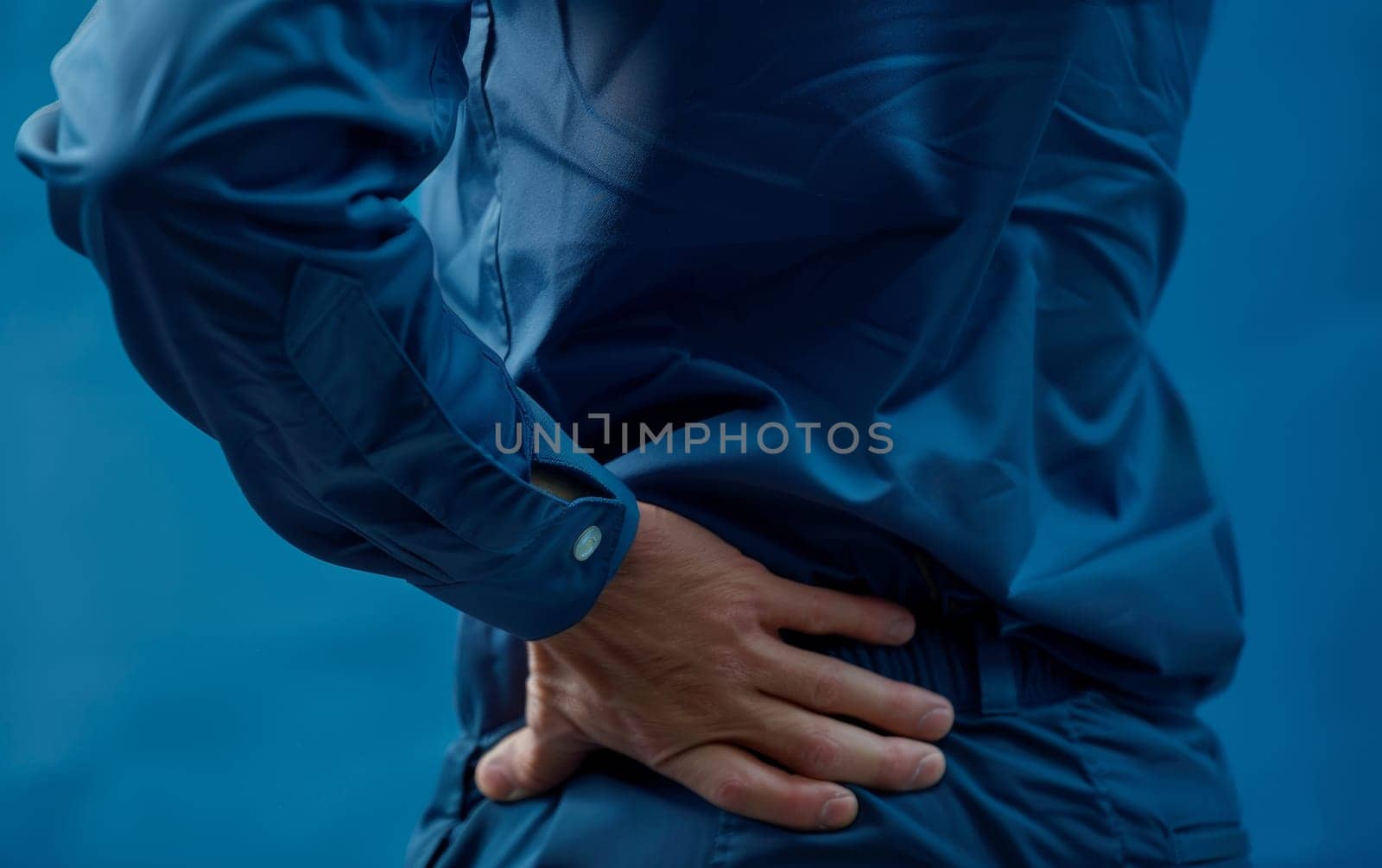 A figure in blue is shown gripping their lower back in pain. The stark blue tone adds an intense, clinical feel to the concept of backache