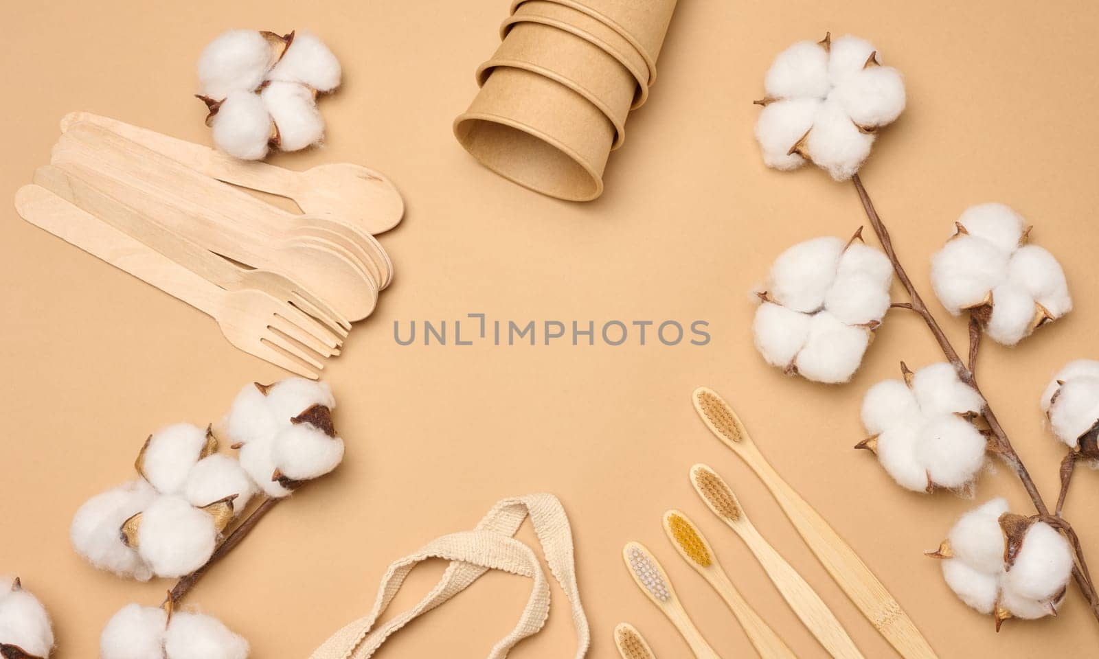 Cotton bag, wooden spoon and cups on a brown background. Waste recycling concept by ndanko