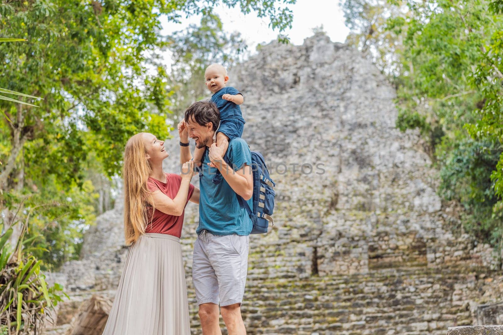 Mom, dad and baby tourists at Coba, Mexico. Ancient mayan city in Mexico. Coba is an archaeological area and a famous landmark of Yucatan Peninsula. Cloudy sky over a pyramid in Mexico by galitskaya