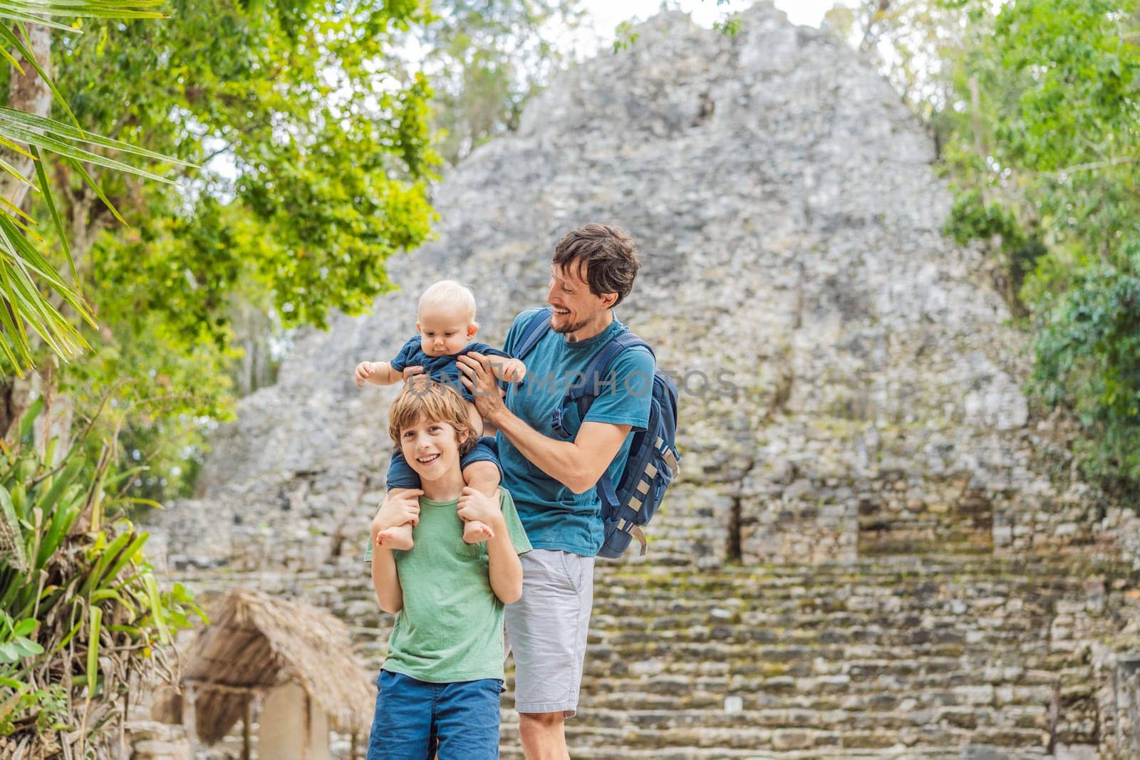 Dad with two sons tourists at Coba, Mexico. Ancient mayan city in Mexico. Coba is an archaeological area and a famous landmark of Yucatan Peninsula. Cloudy sky over a pyramid in Mexico by galitskaya
