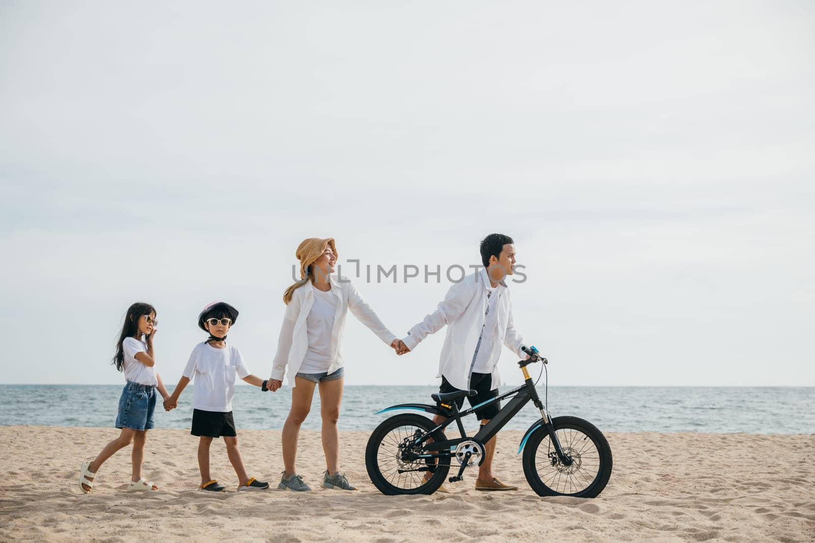 Parents and children enjoy a beach stroll with bicycles a scene full of happiness smiles and the carefree spirit of a childhood day. Family on beach vacation