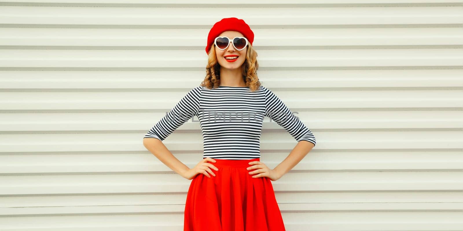 Beautiful happy smiling young woman posing in red skirt, french beret, glasses on white background by Rohappy