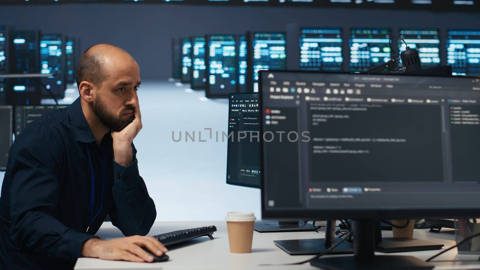Technician using PC in high tech server hub facility to safeguard data from intruding hackers. Engineer protecting blade servers against unauthorized access, securing system from malicious traffic