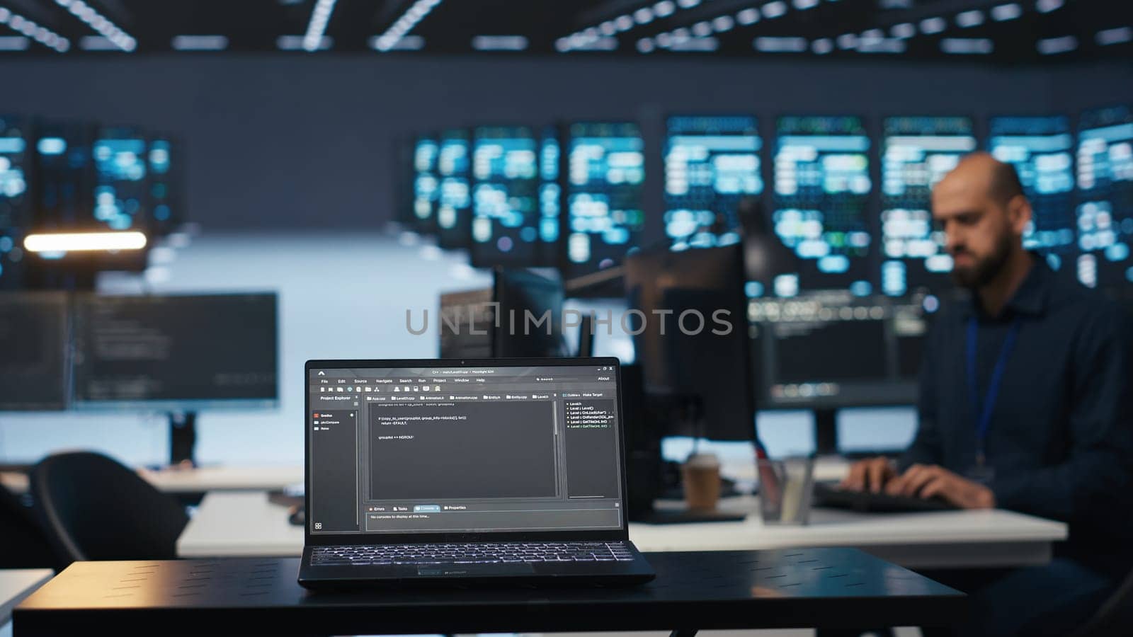 Focus on laptop used by expert in data center running code in blurry background by DCStudio