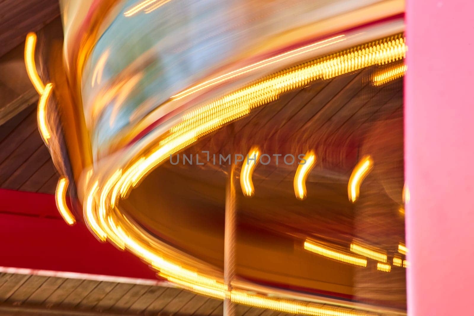 Carousel in motion at Fort Wayne Children's Zoo, Indiana, with golden lights and vibrant blur of colors.