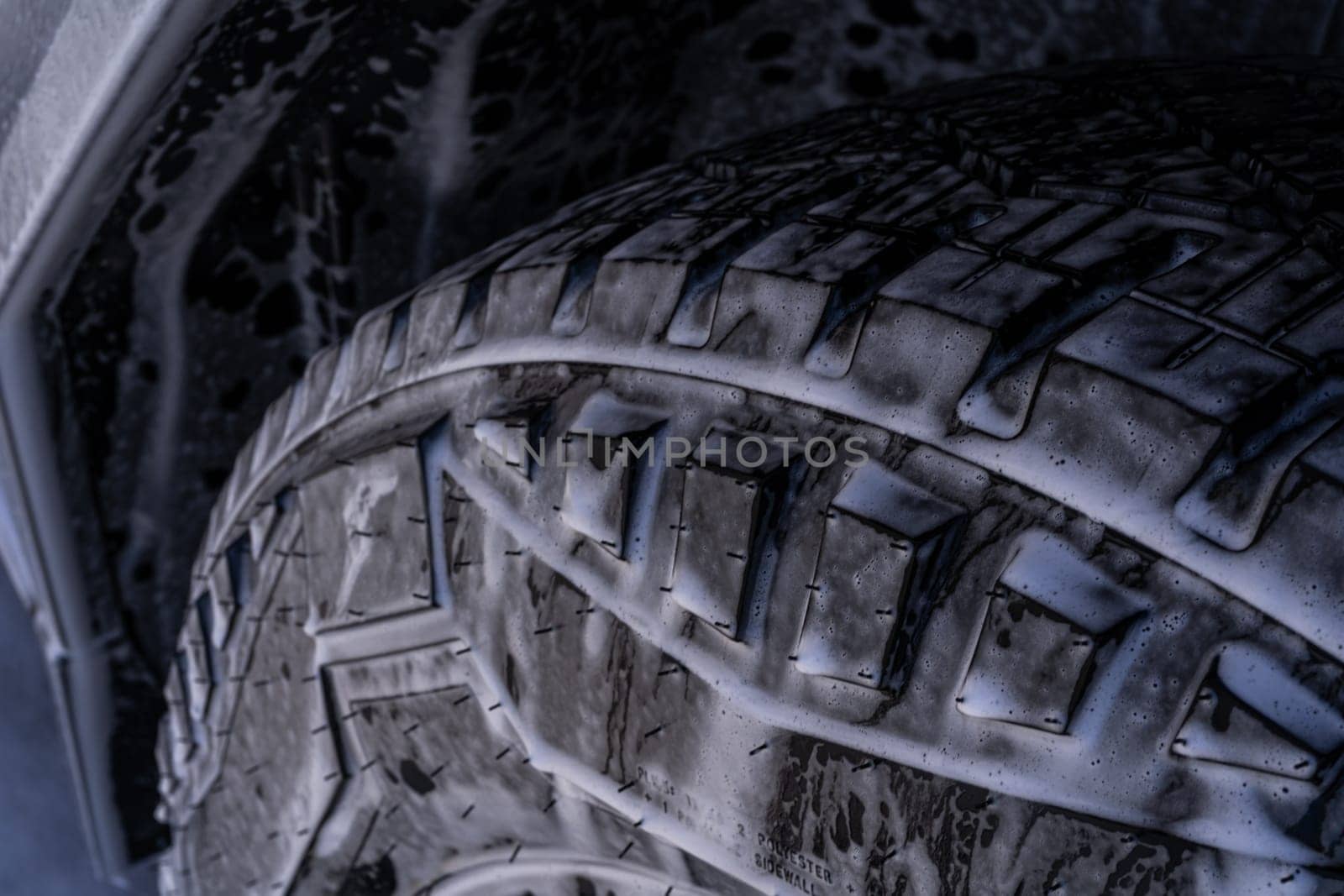 Close-up of Tesla Cybertruck Wheel and Body Covered in Soap by arinahabich