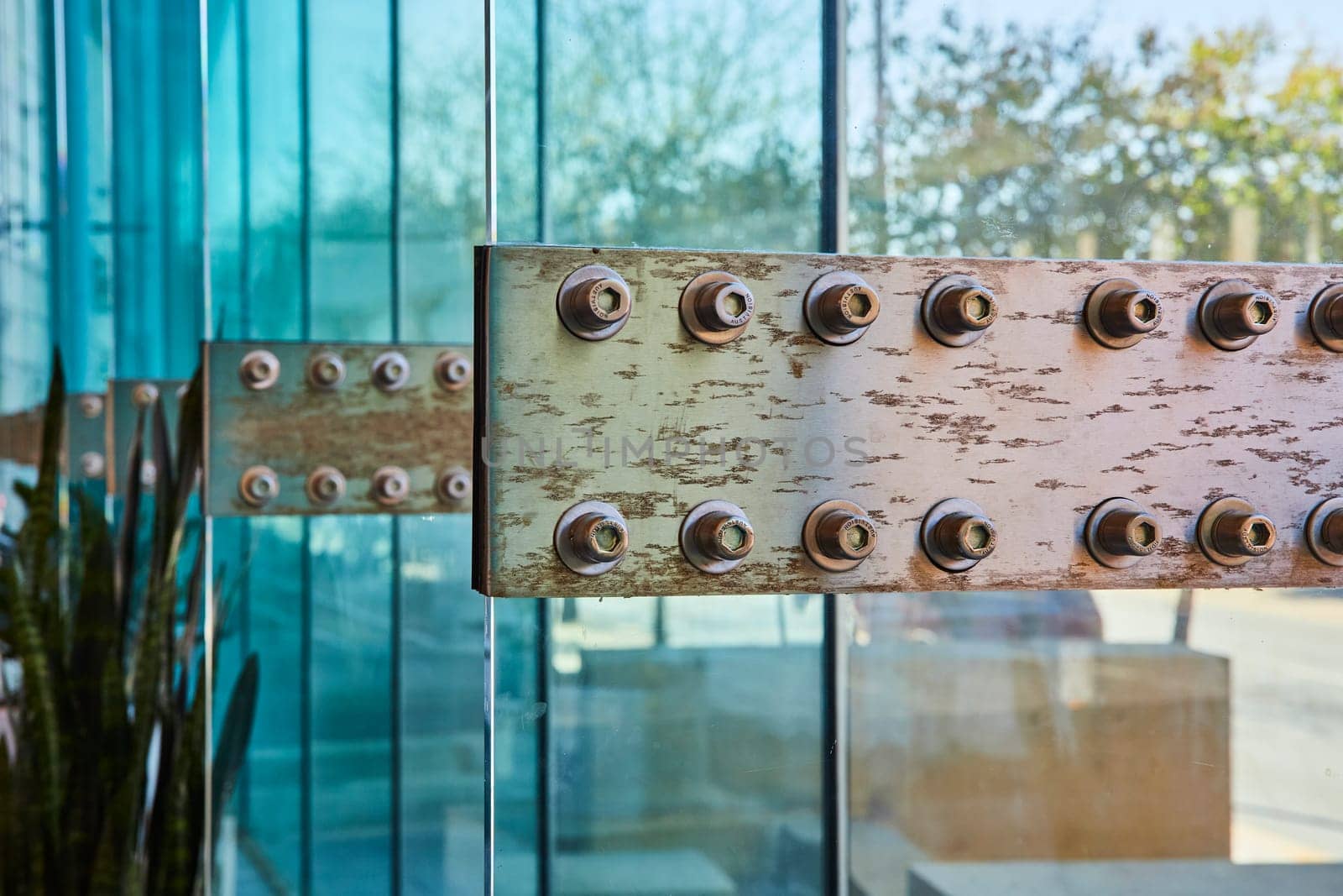 Weathered metal beam with bolts contrasts with reflective glass, Grand Wayne Convention Center, Indiana.