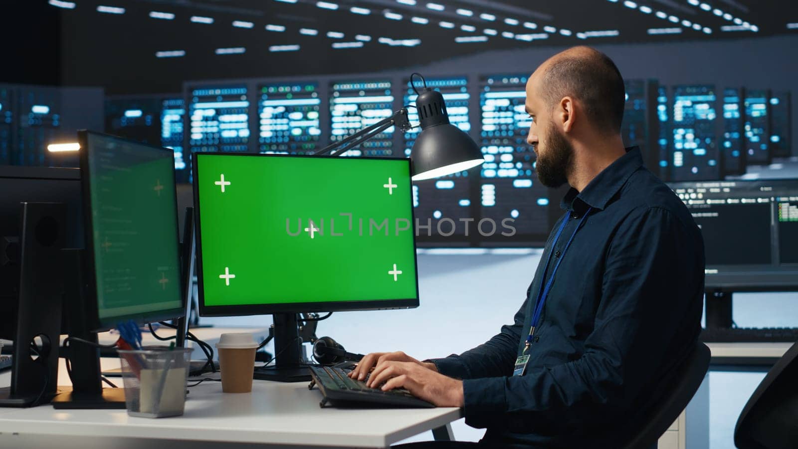 Man typing code on green screen computer in high tech data center by DCStudio