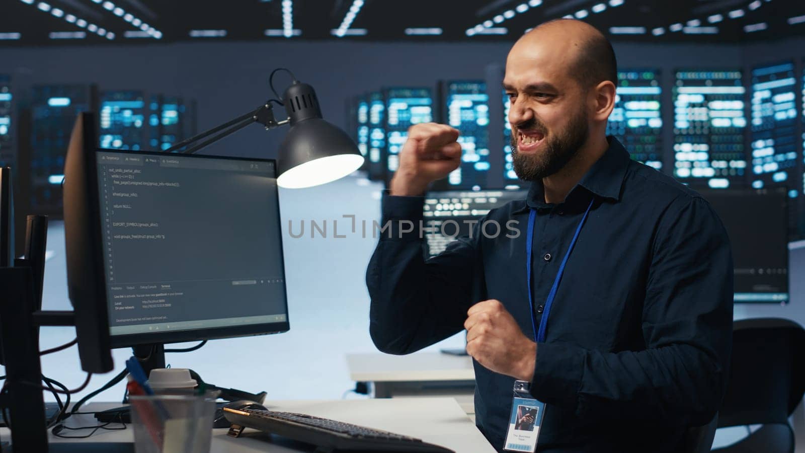 Cheerful man pleased after using PC to fix server cabinets errors in data center by DCStudio