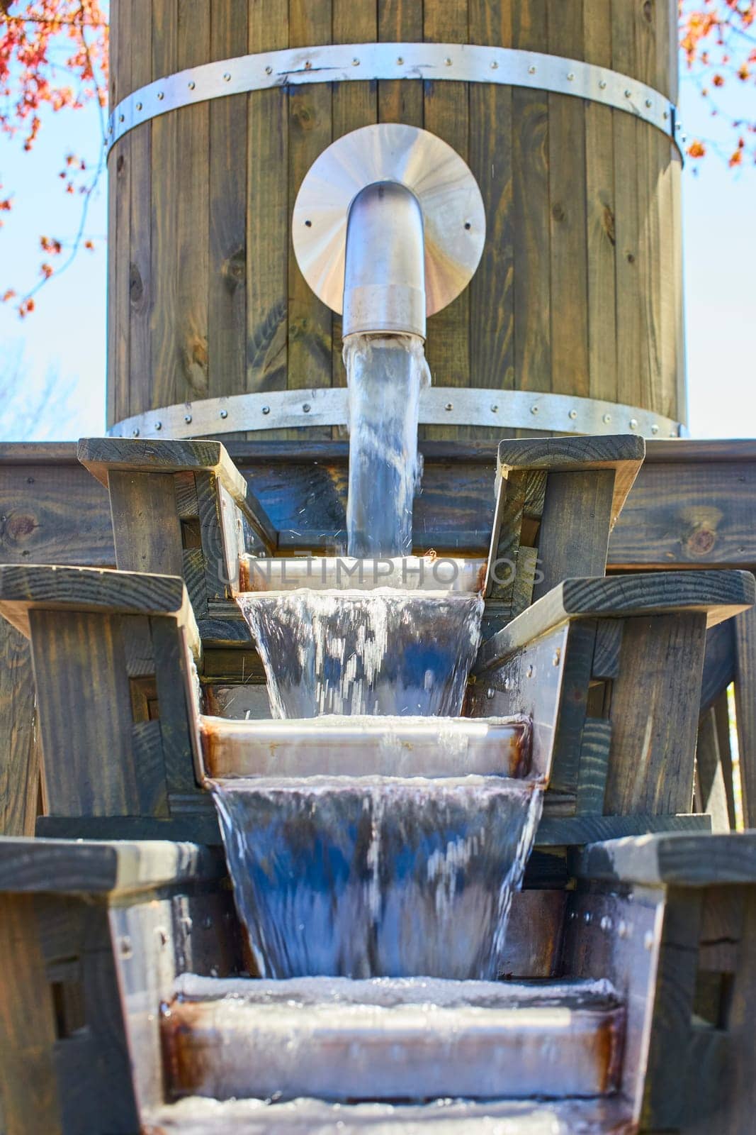 Rustic wooden water feature at Fort Wayne, Indiana flows gently in a serene garden setting.