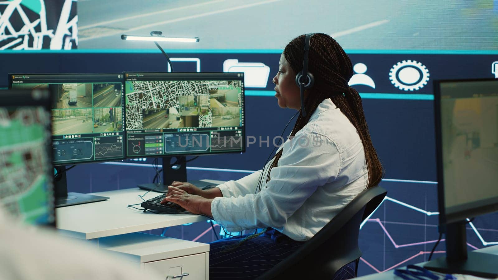 African american operator works on call center at shipping agency, offering real time updates to clients about their order and delivery. Tracking GPS coordinates to arrive at destination. Camera A.